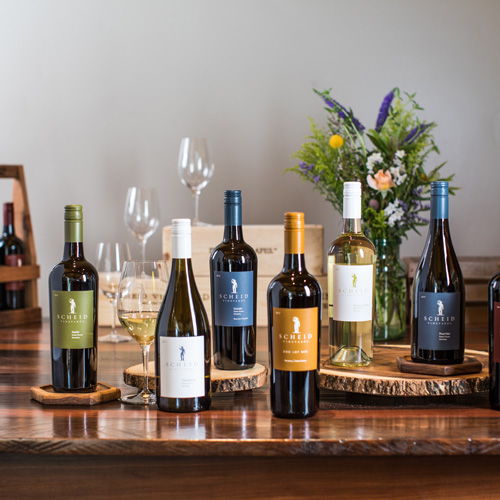 Bottles of Scheid Vineyard wines displayed on a table