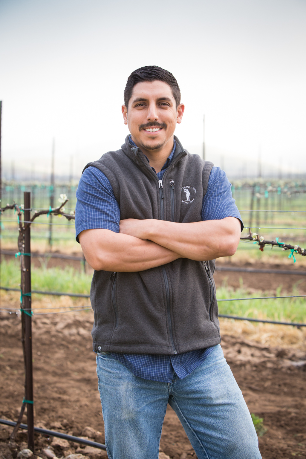 Greg Gonzales posing in front of a vineyard