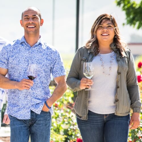 Two people walking in garden with wine glass