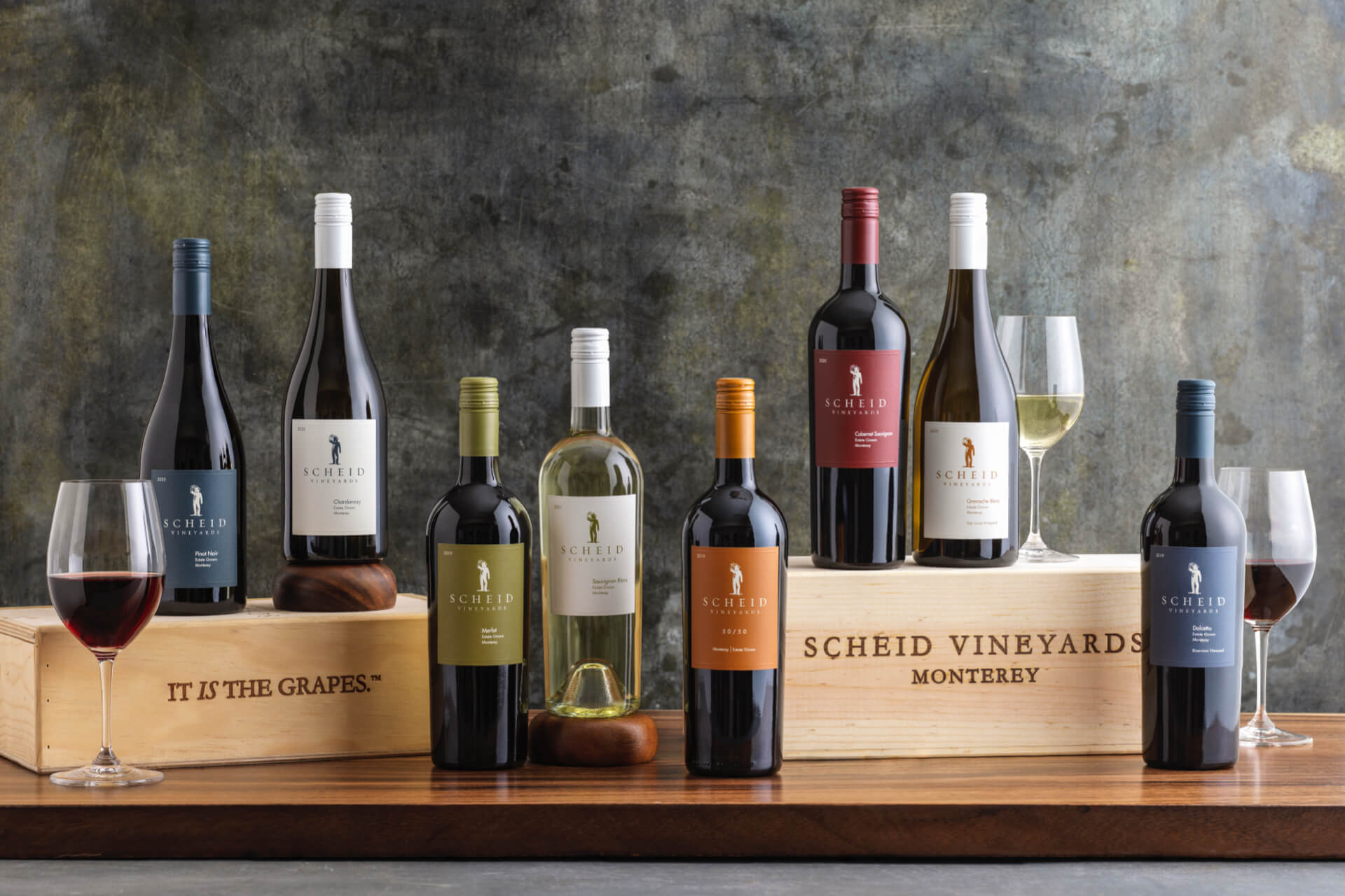 Elegant wine bottles and glasses displayed on wooden crates at Scheid Vineyards.