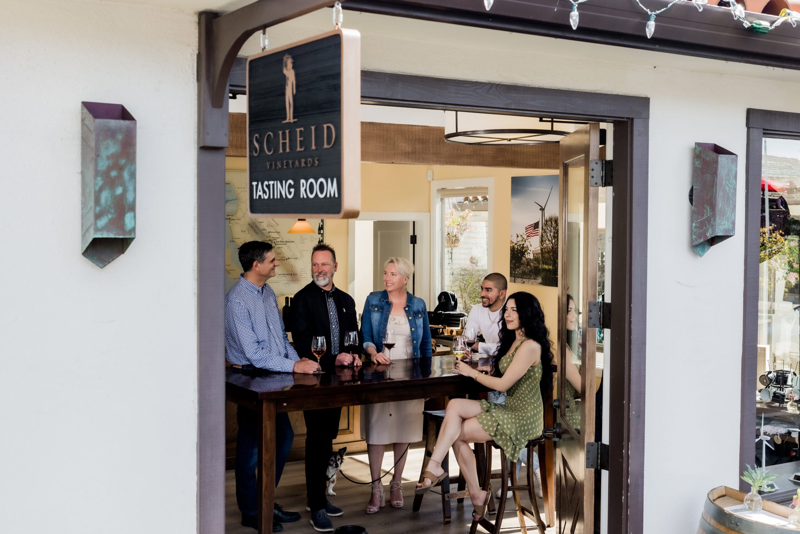 Relaxed wine tasting room with friends at Scheid Vineyards, California winery experience.